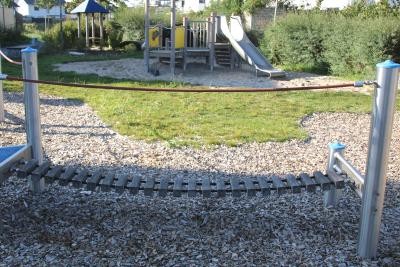 Spielgerät zum Balancieren, im Hintergrund eine Rutsche
