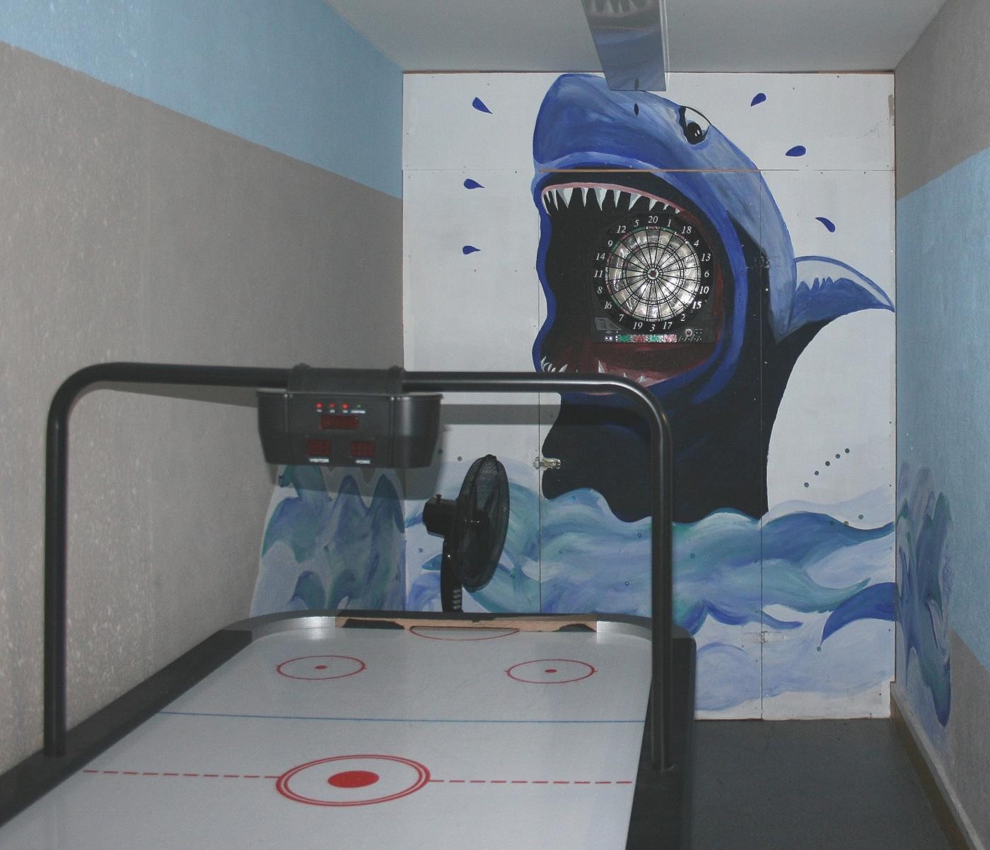 Bild zeigt den Gang des Jugendtreffs mit Dartspiel auf der mit einem Haifisch bemalten Wand